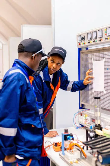 TVET trainees working on an electrical control panel